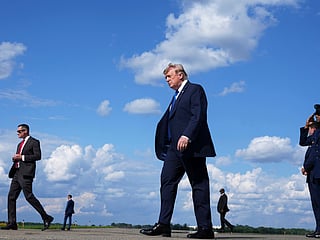 President Donald Trump, center, walks from Air Force One at Morristown Municipal Airport in Morristown, N.J., Friday, July 31, 2026, from Camp David, the presidential retreat. (AP Photo/Jacquelyn Martin)