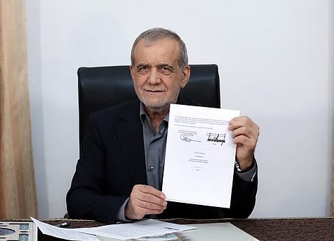 This handout picture released by the Iranian Presidency shows Iran's President Masoud Pezeshkian holds a memorandum of understanding document showing his signature and that of US president Donald Trump, in Tehran on June 18, 2026.