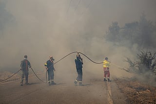 Volunteers and Greek firefighters work to extinguish a wildfire near Porto Germeno, some 70 kilometres  northwest of Athens in the region of Viotia, on August 2, 2026.