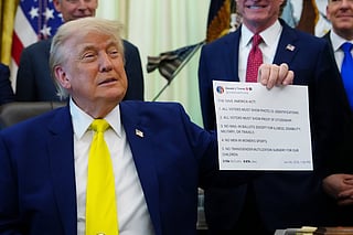 FILE - President Donald Trump holds up an image taken from his Truth Social account at an event about coal, Thursday, June 4, 2026, in the Oval Office of the White House in Washington. (AP Photo/Julia Demaree Nikhinson,File)