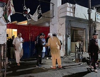 Police officials inspect the site following a suicide bombing during a protest in Pakistan's Swat district.