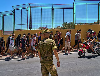 Migrants who crossed into Spain are escorted by Spanish soldiers toward the Spanish-Moroccan border for their return to Morocco from the Spanish enclave of Ceuta.