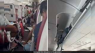 Overhead bin flaps hang open above the aisle after violent turbulence rocked the Air India flight from Phuket to Delhi.