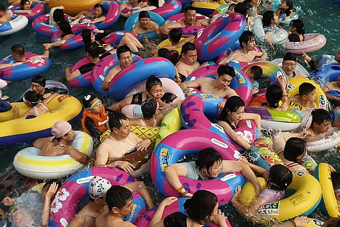 People pack into a wave pool at an ocean park as they seek relief from the heat in Shenyang, northeastern China's Liaoning province.