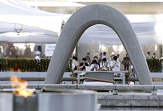 Visitors pray in front of the cenotaph dedicated to the victims of the atomic bombing ahead of a ceremony to mark the anniversary of the bombing at the Hiroshima Peace Memorial Park in Hiroshima, western Japan Thursday, Aug. 6, 2026.
