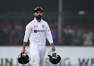 (FILES) India's captain Ajinkya Rahane carries helmets on the fifth and final day of the first Test cricket match between India and New Zealand at the Green Park Stadium in Kanpur on November 29, 2021. India's Ajinkya Rahane announced his retirement from international cricket on July 30, bringing the curtain down on a career highlighted by his leadership during a remarkable 2021 Test series victory in Australia. 