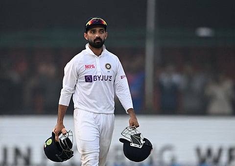 (FILES) India's captain Ajinkya Rahane carries helmets on the fifth and final day of the first Test cricket match between India and New Zealand at the Green Park Stadium in Kanpur on November 29, 2021. India's Ajinkya Rahane announced his retirement from international cricket on July 30, bringing the curtain down on a career highlighted by his leadership during a remarkable 2021 Test series victory in Australia. 