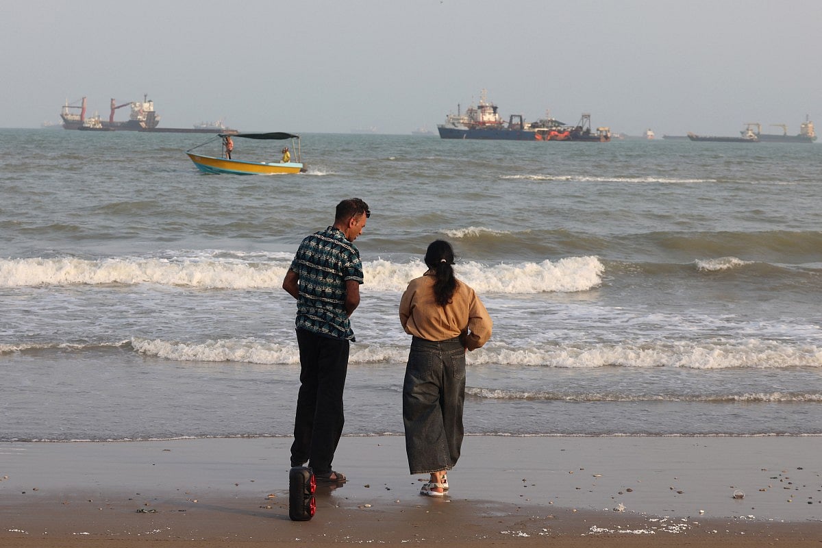 Iranians enjoy the seaside as vessels are seen in the Strait of Hormuz off Bandar Abbas, in southern Iran on August 10, 2026.