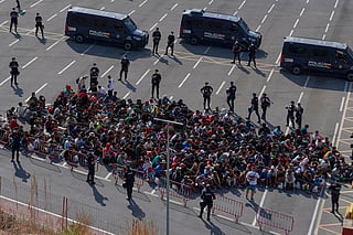 Migrants who crossed from Morocco into Spain are escorted by Spanish police to temporary shelters after being cleared from a beach in the Spanish exlave of Ceuta on Thursday, Aug. 20, 2026.