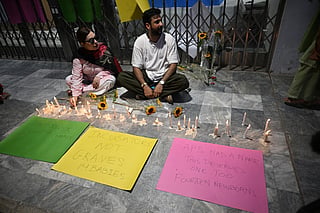 Activists light candles next to flowers placed outside the Mother and Child Health ward to protest against the death of infants in a fire at the Pakistan Institute of Medical Sciences (PIMS) Hospital in Islamabad on August 27, 2026.