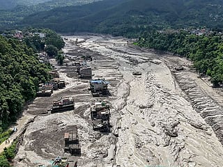 Houses lie partially submerged in muddy water along a riverside after flash floods at Trishuli Bazar in Nepal's Nuwakot district.
