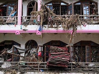 Mattresses and debris is seen coming out of windows of a damaged house in the aftermath of flash floods at Devighat in Nepal's Nuwakot district