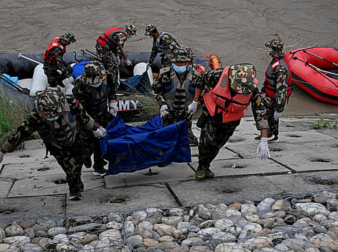 Nepal's army personnel carry the bodies of deceased flood victims during a search operation along the Narayani river at Bharatpur in Nepal's Chitwan district on August 31, 2026.