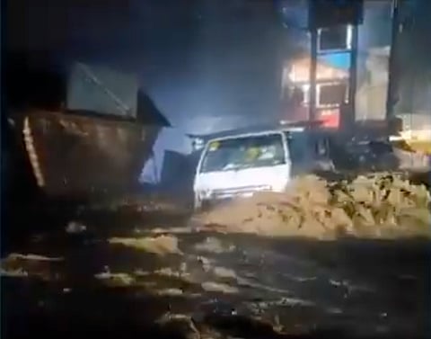 Screengrab from a citizen video post shows a small truck swept away by strong floodwaters in Rizal province, east of Manila.