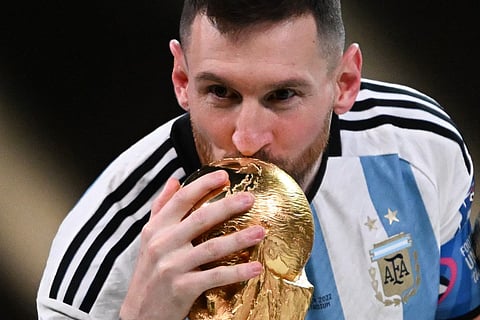 Argentina's captain and forward #10 Lionel Messi kisses the FIFA World Cup Trophy during the trophy ceremony after Argentina won the Qatar 2022 World Cup final football match between Argentina and France at Lusail Stadium in Lusail, north of Doha on December 18, 2022.