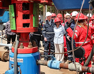 This handout picture released by the Venezuelan Presidency shows Venezuela's Interim President Delcy Rodriguez (C), US Secretary of Energy Chris Wright (L), US diplomatic mission to Venezuela, Laura Farnsworth Dogu (R), and workers from the state oil company Petroleos de Venezuela (PDVSA) during a visit to the Orinoco oil belt in southern Venezuela on February 12, 2026.