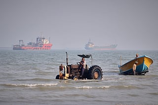 A tractor pulls a boat from the sea as commercial vessels are anchored in the Strait of Hormuz off Bandar Abbas, Iran, on Aug. 31, 2026.   The US says Iran was preparing to deploy rocket-launched sea mines.