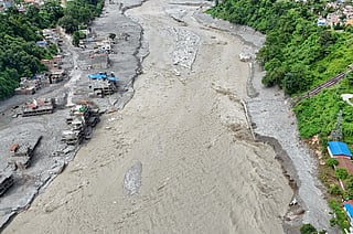 An aerial view shows a torrent of muddy water surging past houses and through the Trishuli River in the aftermath of flash floods at Trishuli Center in Nepal's Nuwakot district on September 1, 2026.