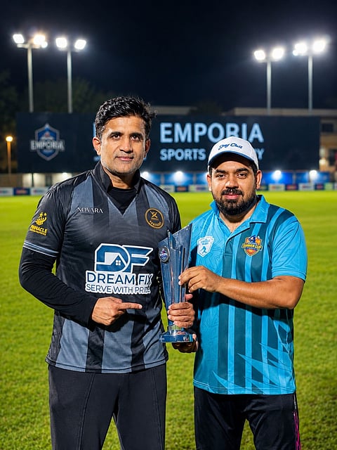 Omar Farooq receiving his winner's trophy from Faisal Siddiqui.