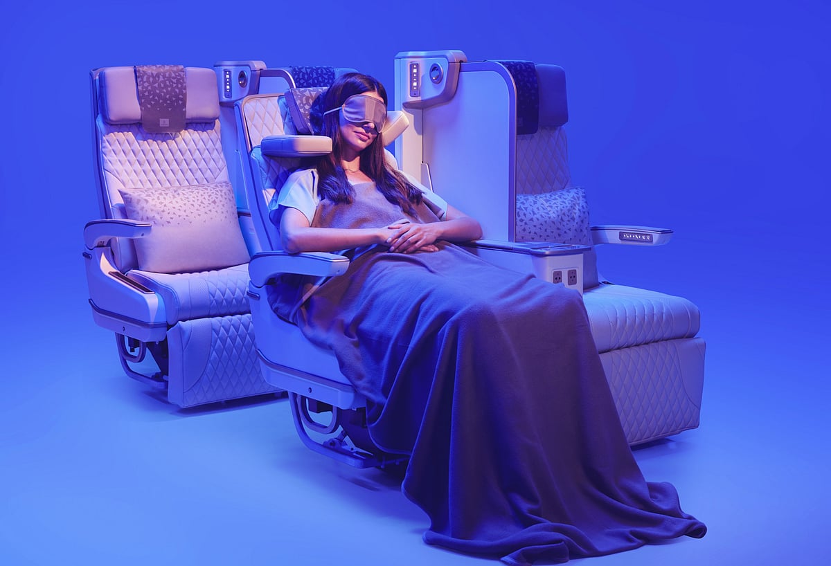 This image shows a customer relaxing in Emirates’ new Premium Economy seat, featuring the globally acclaimed U-Dream headrest by Safran Seats for enhanced neck and head support, alongside an electrically deployable leather footrest and adjustable seating positions.