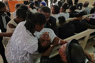 A grieving relative is comforted during a funeral service for victims of a gang attack in the Kenscoff neighborhood of Port-au-Prince, Haiti, Wednesday, Sept. 2, 2026. (AP Photo/Odelyn Joseph)