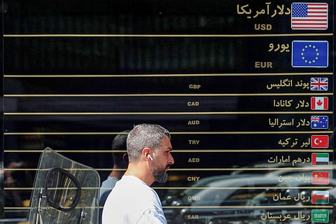 A man walks past a currency exchange along a street in Tehran on September 7, 2026.