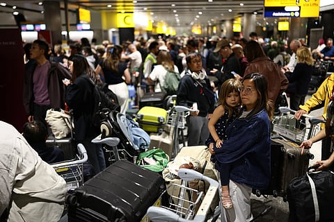 Delayed passengers wait and queue with their luggage at Terminal 3 of London Heathrow airport, west of London on September 8, 2026, following major disruption due an issue affecting the NATS air traffic control systems.