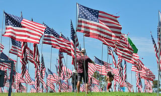 Visitors walk through US flags displayed at Pepperdine University in Malibu, California, on September 9, 2026, as part of the annual Wave of Flags commemorating the September 11, 2001 attacks.
