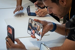 An attendee takes a selfie with the new foldable iPhone Duo, displayed during an Apple event at the Steve Jobs Theater in Apple Park in Cupertino, California, on September 9, 2026.
