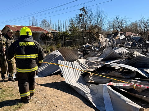 Firefighters inspect the scene following a fire at a nursing home which has killed 16 people, in Pitrufquen, Araucania region, Chile on September 12, 2026.