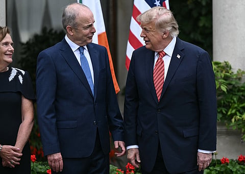 US President Donald Trump (R) speaks with Ireland's Prime Minister Micheál Martin (C) and his wife Mary O'Shea (L) as he is welcomed at Farmleigh House in Phoenix Park in the Irish capital Dublin on September 12, 2026.