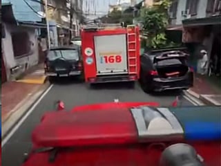 A double-parked sedan on a narrow road left a BFP fire truck struggling to pass.