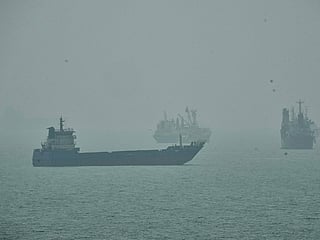 Commercial vessels anchored amid haze in the Strait of Hormuz off Bandar Abbas, Iran