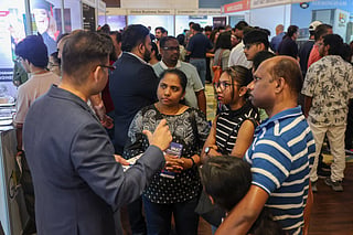 Families discussing study opportunities with exhibitors 