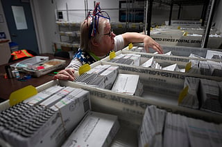 FILE - Election worker Wendy Wimer looks through vote-by-mail ballots for the presidential primary election, March 12, 2024, at the Clark County Elections Office in Vancouver, Wash. (AP Photo/Jenny Kane, File)