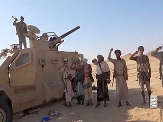 Houthi rebels in Yemen posing next to a captured vehicle (Photo/Reuters)