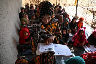 An Afghan girl reads a book at a school in Zhari district of Afghanistan's Kandahar province on September 16, 2026. UNICEF estimates that around 640 million girls and women alive today were married in childhood.