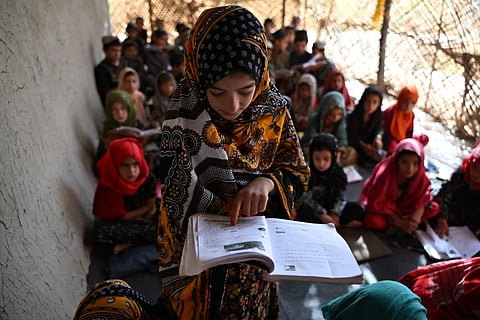 An Afghan girl reads a book at a school in Zhari district of Afghanistan's Kandahar province on September 16, 2026. UNICEF estimates that around 640 million girls and women alive today were married in childhood.
