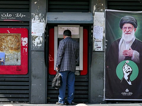 A man uses an automated teller machine (ATM) from Bank Mellat in Tehran on September 7, 2026.