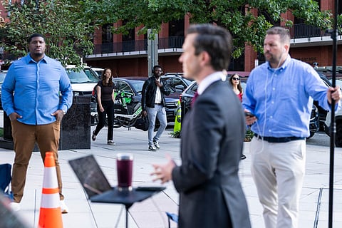 Pedestrians pass as MS NOW White House Correspondent Vaughn Hillyard delivers a television report on a street corner outside the White House grounds on September 21, 2026 in Washington, DC. Reporters from MS NOW, CNN, and Politico have been blocked from accessing the White House since September 19th after President Trump said he was banning the three outlets from the property.