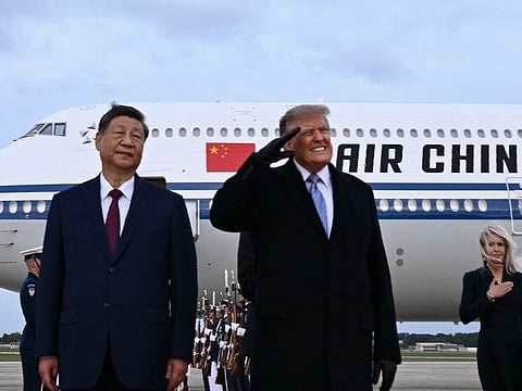 US President Donald Trump reacts after a B1 bomber flew past during the national anthems while he greeted Chinese President Xi Jinping upon his arrival at Joint Base Andrews in Maryland on September 23, 2026.