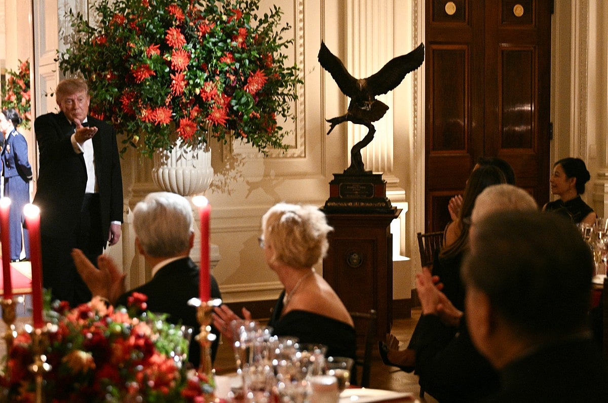 US President Donald Trump gestures towards China's President Xi Jinping as he presents him with a sculpture of a bald eagle during a State Dinner at the White House in Washington, DC, on September 24, 2026.
