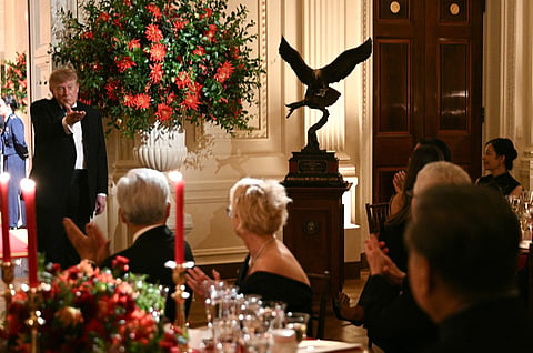 US President Donald Trump gestures towards China's President Xi Jinping as he presents him with a sculpture of a bald eagle during a State Dinner at the White House in Washington, DC, on September 24, 2026.