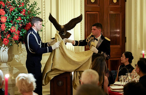 US President Donald Trump gestures towards China's President Xi Jinping as he presents him with a sculpture of a bald eagle during a State Dinner at the White House in Washington, DC, on September 24, 2026.