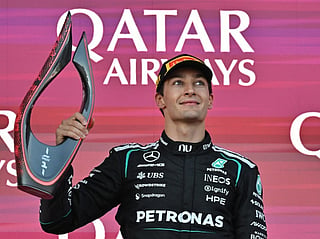 Winner Mercedes' British driver George Russell celebrates with the trophy during the podium ceremony for the Formula One Azerbaijan Grand Prix at the Baku City Circuit in Baku on September 26, 2026.