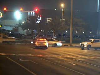 Sharjah Police camera captures a driver running a red light at night.