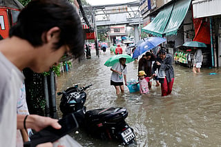 People wade through floodwaters in the Bang Bua district of Bangkok on September 26, 2026.