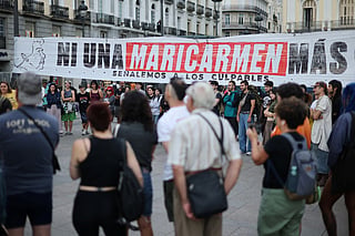People gather next to a banner reading 'Not a single more Maricarmen' - in reference to an 87-year-old evicted from her Madrid home - as demonstrators camp to protest against evictions and the housing crisis in front of the Presidency of the Community of Madrid on the Puerta del Sol plaza in Madrid on September 27, 2026.