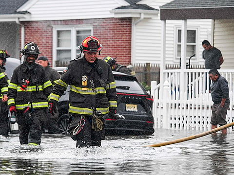 Firefighters of the Atlantic City Fire Department respond to a vehicle fire call in flood waters in Atlantic City, New Jersey.