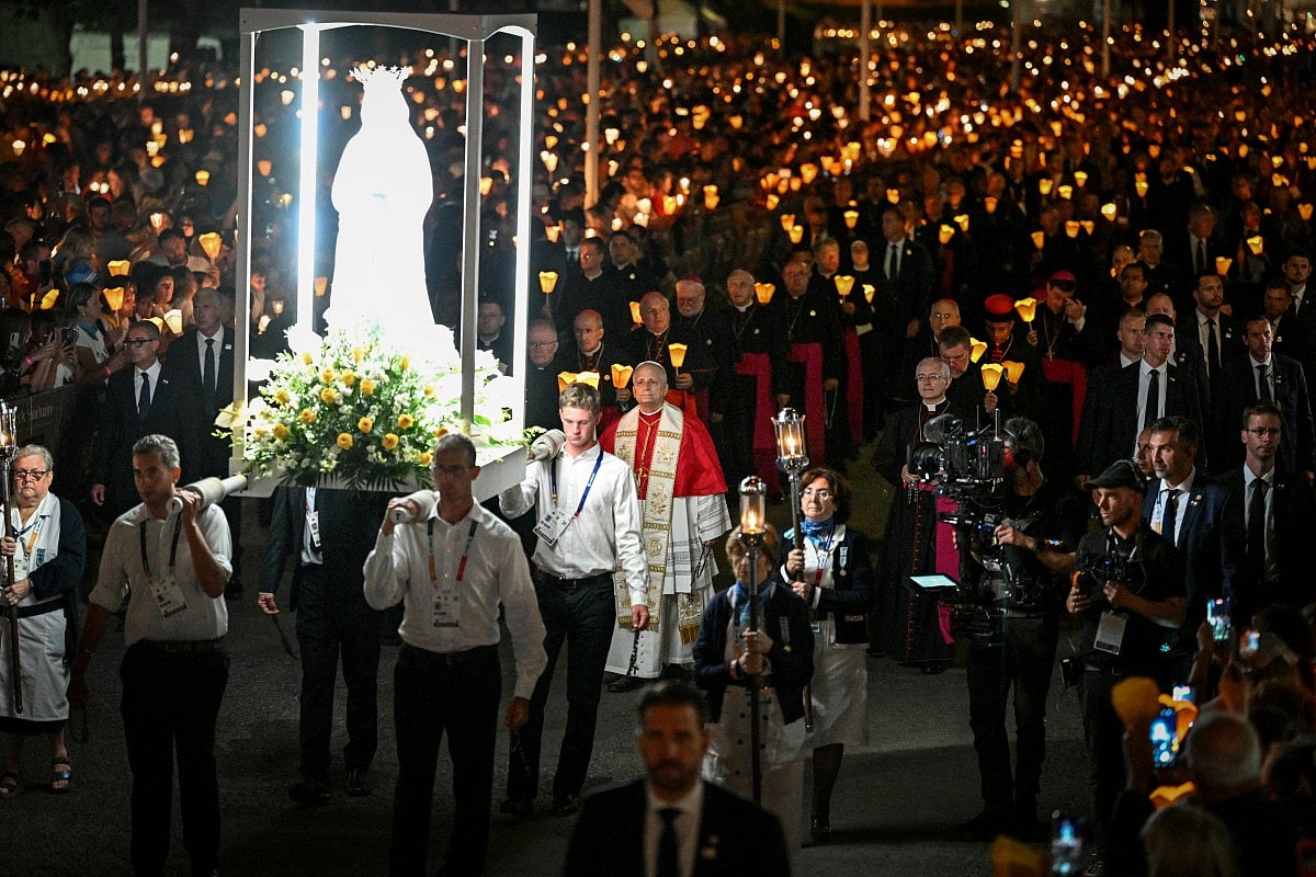 Pope Leo XIV (C) takes part in a torchlight procession following the Rosary Prayer at the Shrine of Our Lady of Lourdes, southwestern France, on September 27, 2026 on the third day of his visit to France.